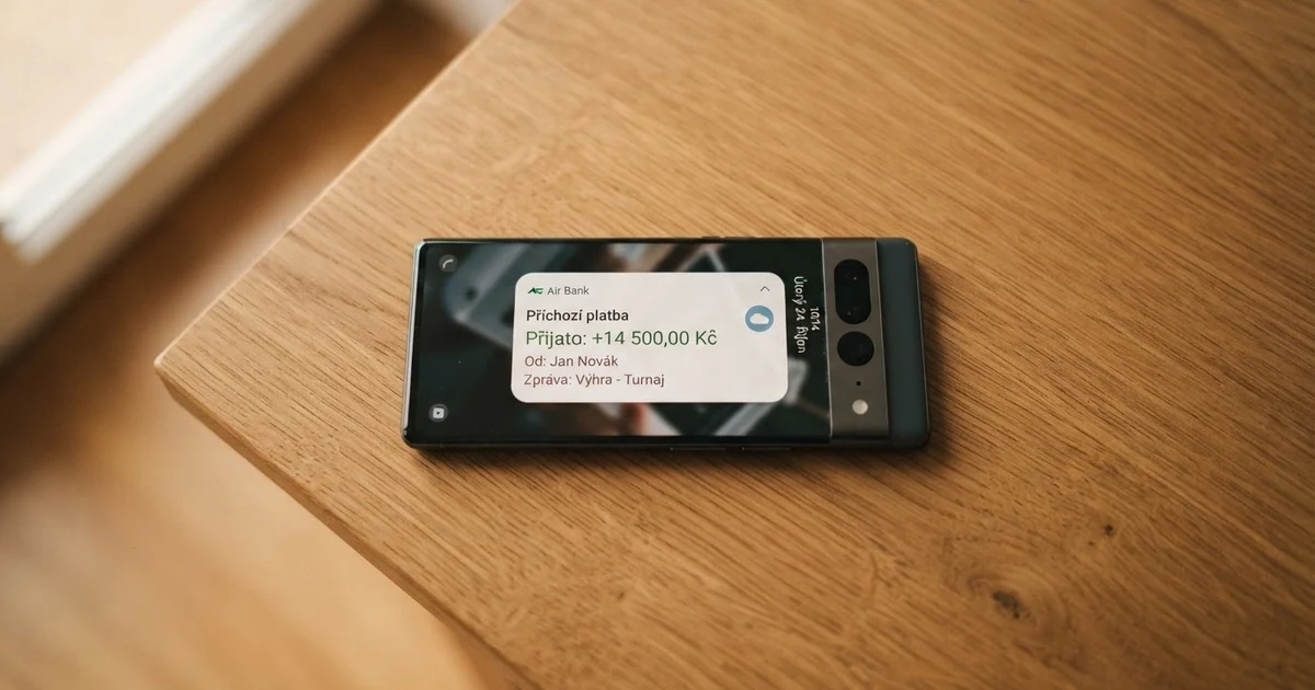 Hráč kontrolující příchozí platbu na mobilním telefonu, na obrazovce notifikace bankovní aplikace